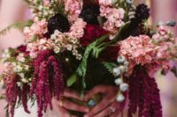 a bright wedding bouquet of pink hdyrangeas, deep purple blooms, berries, greenery and amaranthus is amazing for the fall