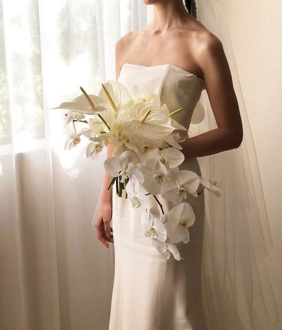 a cascading wedding bouquet of white anthurium and orchids is a chic and stylish idea for a modern wedding