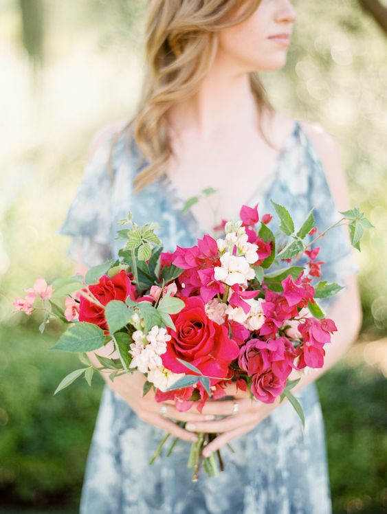 a catchy summer wedding bouquet of bougainvillea, white fillers and red roses plus greenery for a colorful wedding
