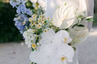 a catchy wedding bouquet of blue blooms, white hydrangeas, chamomiles, orchids and anthurium is a cool idea