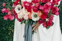a catchy wedding bouquet of bougainvillea, white anemones, peony roses and ranunculus, orange blooms and foliage