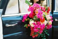 a chic and bold wedding bouquet of bougainvillea, white and blush roses, ranunculus, greenery and foliage for a colorful wedding
