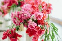 a chic and bold wedding centerpiece of pink roses and bougainvillea plus some greenery is amazing for destination wedding