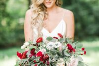 a chic and bright wedding bouquet of white anemones, blush roses, red ranunculus, amaranthus and greenery for a wedding with a touch of red