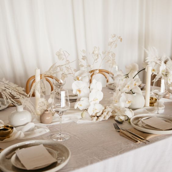 a chic modern wedding centerpiece of white orchids and lunaria plus dried grasses is a lovely idea for a neutral celebration