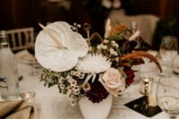 a chic wedding centerpiece of white roses, dahlias, anthuriums, rust and white fillers and greenery is a catchy and unique idea
