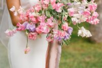 a colorful and dimensional wedding bouquet of pink, blush and purple sweet peas plus leaves is amazing for spring or summer