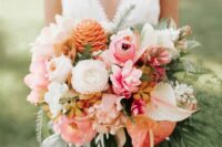 a colorful tropical wedding bouquet of pink and peachy blooms, white flowers and anthurium of various colors plus fronds and leaves