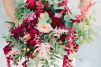 a colorful wedding bouquet of blush, pink and red roses, burgundy dahlias, greenery, berries and amaranthus for the fall