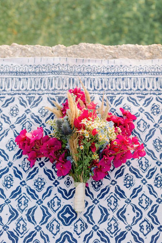 a colorful wedding bouquet of bougainvillea, wildflowers, thistles and greenery plus bunny tails for a boho wedding