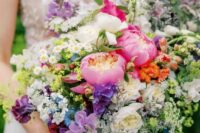 a colorful wedding bouquet of coral peonies, neutral peony roses, small fillers, greenery, purple and lilac sweet peas