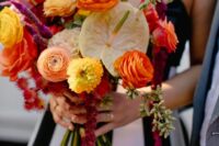 a colorful wedding bouquet of orange ranunculus, roses and neutral anthurium, some amaranthus and greenery