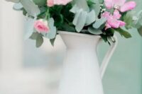 a delicate summer wedding centerpiece of a white jug with blush and pink blooms and greenery is a cool idea to DIY