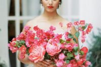 a dimensional wedding bouquet of coral peonies and bougainvillea plus greenery for a Mediterranean wedding
