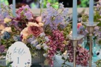 a dreamy wedding centerpiece of blush roses, blue sweet peas, some periwinkle and pink fillers for a spring wedding