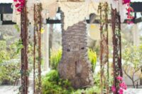 a fairy-tale wedding arch covered with doilies, bougainvillea and greenery plus a rug is a bold and lovely idea for a summer wedding