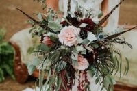 a fall wedding bouquet of blush peony roses, burgundy mums, king proteas, greenery, feathers and amaranthus is wow