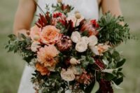 a fall wedding bouquet of peachy, white and pink blooms, greenery, berries and amaranthus and billy balls is a catchy idea