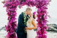 a fantastic hot pink and fuchsia wedding arch totally covered with blooms is a bright and statement-like idea for a wedding