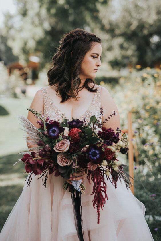 a fantastic wedding bouquet of blush roses, burgundy dahlias and lilies, purple anemones, grasses and amaranthus for a fall or Halloween wedding