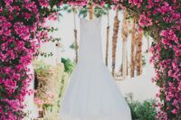 a gorgeous lush wedding arch covered with bougainvillea and greenery is a stunning idea for a tropical wedding
