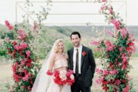 a gorgeous modern wedding arch decorated with greenery, bougainvillea and red roses is a fantastic idea for a modern celebration