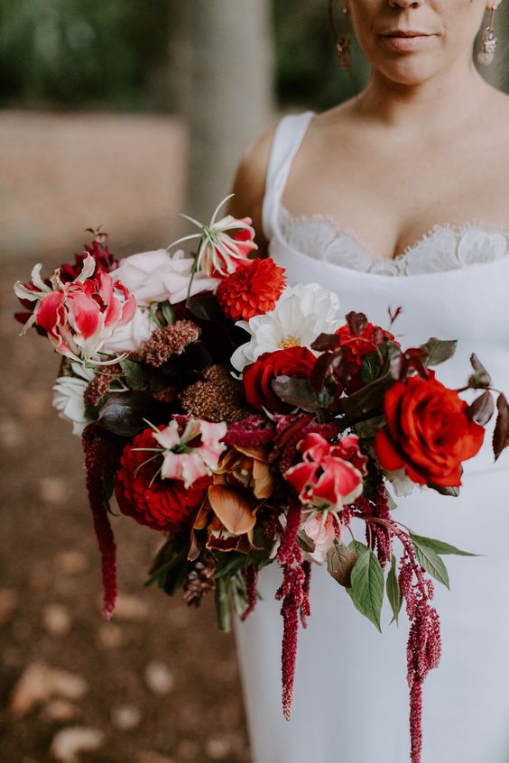 a gorgeous wedding bouquet of white, red and deep red blooms, some dark foliage and amaranthus is wow
