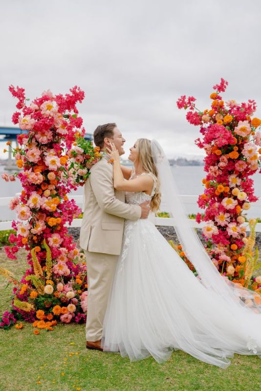 a jaw-dropping wedding altar with bougainvillea, peonies, orange mumes, greenery and astilbe for a tropical wedding