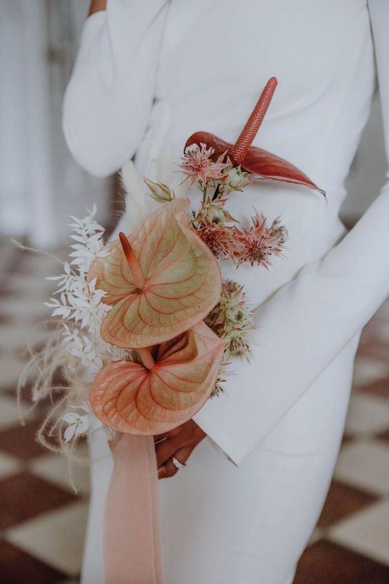 a laconic modern wedding bouquet of blush and burgundy anthurium, dried grasses and some smaller fillers is a catchy idea
