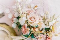 a lively wedding bouquet of blush and peachy roses, lunaria, greenery and some leaves is a cool idea for spring or summer