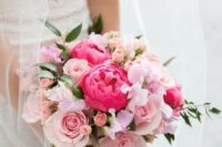 a lovely wedding bouquet of light pink roses, coral peonies, blush garden roses and pink sweet peas plus greenery