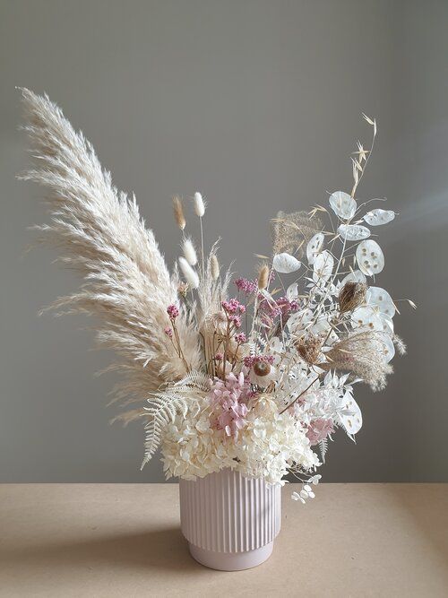 a lovely wedding centerpiece of lunaria, pampas grass, bunny tails, white hydrangeas, dried blooms and dried leaves is a cool idea