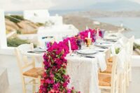 a lovely wedding tablescape with a view and a gorgeous red and magenta bloom table runner is fantastic
