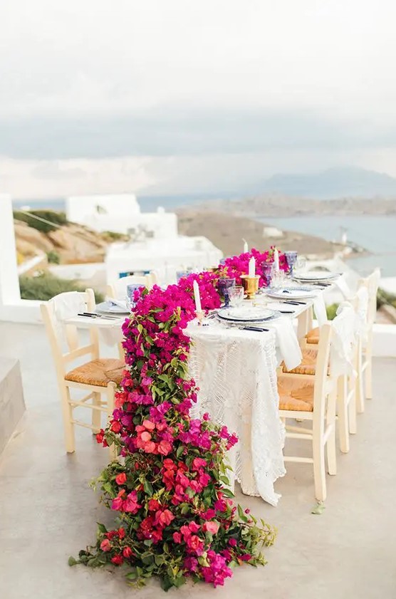 a lovely wedding tablescape with a view and a gorgeous red and magenta bloom table runner is fantastic