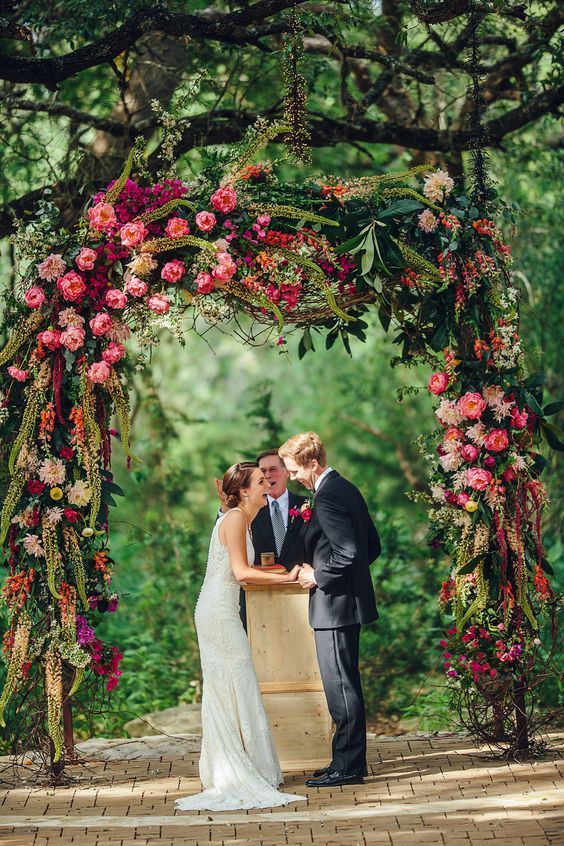 a lush and vibrant wedding arch with pink and fuchsia blooms, greenery and green amaranthus is a stunning solution with much color