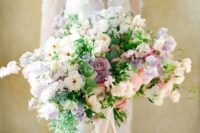a lush pastel wedding bouquet of blush, lilac and neutral blooms, lilac sweet peas, lilac blooming branches and greenery is amazing for spring