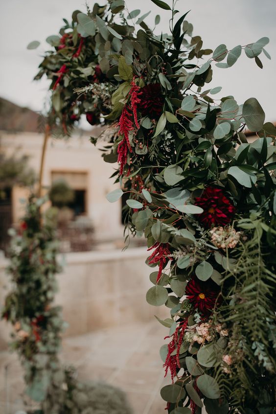a lush textural wedding arch with lots of various greenery, blush blooms, amaranthus is a cool solution for a fall wedding