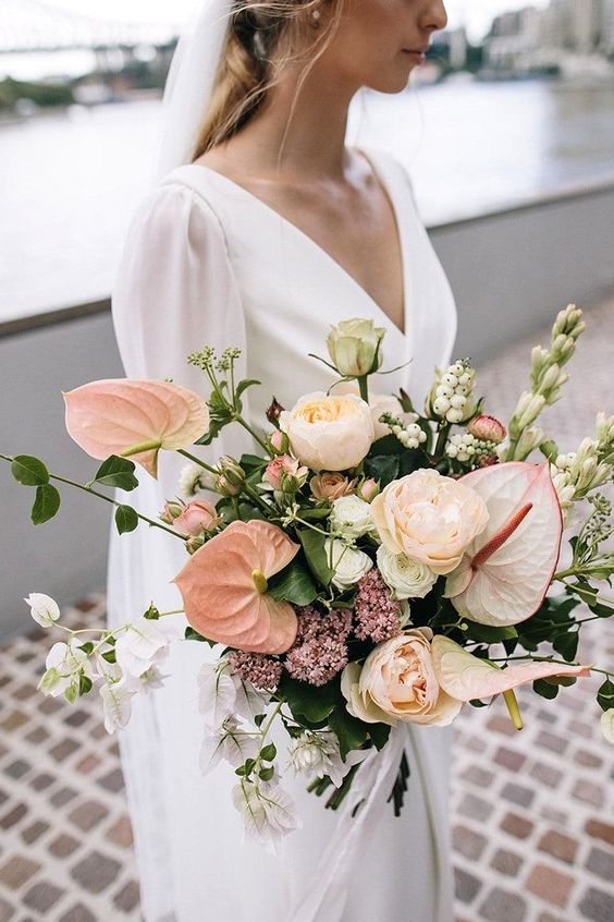 a lush wedding bouquet of blush anthurium, peonies, garden roses, various fillers and greenery is a cool idea for a wedding
