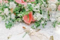 a lush wedding centerpiece of white blooms and greenery, coral anthuriums and blush blooms is amazing for a garden wedding