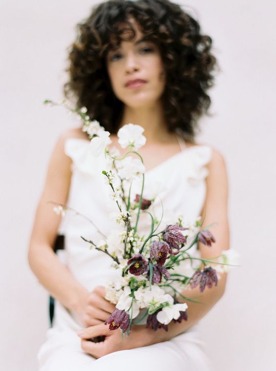 a minimal wedding bouquet of white sweet peas and some dark blooms is a lovely idea for a modern or minimal bride