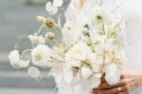 a modern white wedding bouquet of mums, lunaria and seed pods plus bunny tails is a cool and edgy solution