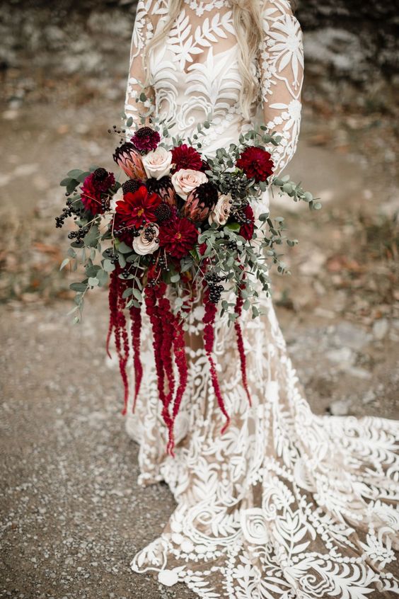 a moody wedding bouquet of blush roses, burgundy dahlias, king proteas, greenery, berries and amaranthus for the fall