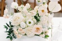 a neutral and refined wedding centerpiece of white anthuriums, blush and white roses, fillers and greenery