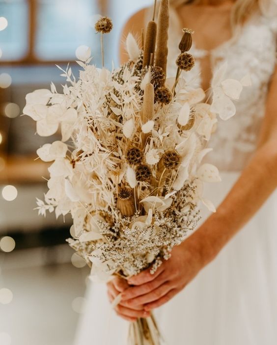 a neutral boho wedding bouquet of lunaria, seed pods, some dried leaves and grasses is a chic and creative idea for a wedding