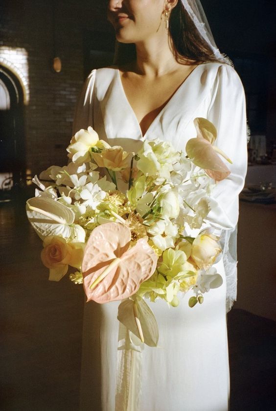 a neutral wedding bouquet of white blooms, roses and others plus blush anthurium is a spectacular idea