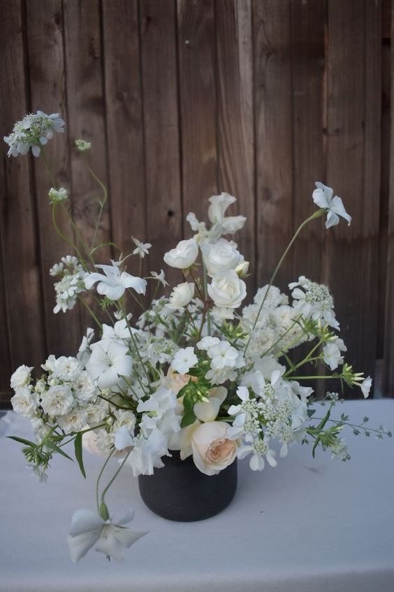 a neutral wedding centerpiece of blush peonies, white roses and sweet peas is a lovely idea for a modern neutral wedding