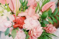 a pink wedding bouquet of various tropical blooms including anthurium and with greenery is a cool idea