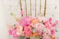 a pink wedding centerpiece of light pink, hot pink, fuchsia and blush blooms and greenery is a gorgeous idea for a spring or summer wedding