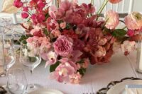 a pink wedding centerpiece of orchids, carnations, ranunculus and anthurium is a fantastic idea