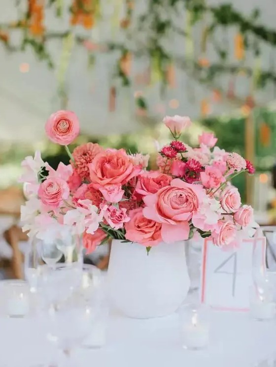 a pink wedding centerpiece of peonies, ranunculus, white fillers and pink carnations is amazing for a romantic wedding
